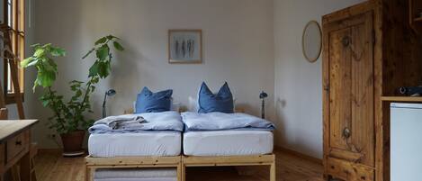 Een knus slaapkamer met een houten bed, een potplant, een bureau en een kledingkast.