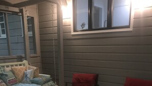 Un soggiorno accogliente con camino, un divano con cuscini decorati e due poltrone rosse.