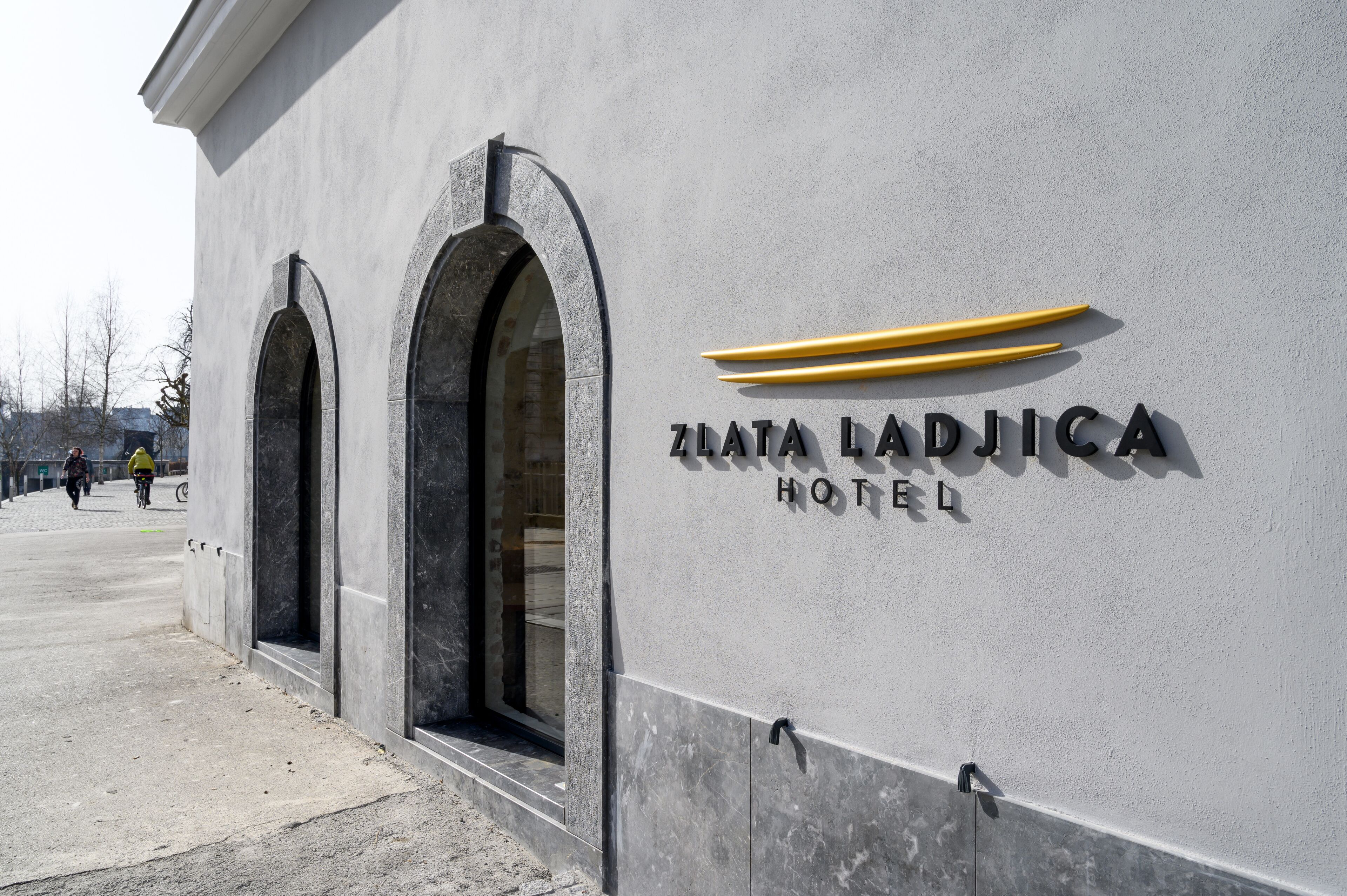 The exterior of the Ziata Ladjica Hotel with a modern facade, large arched windows, and a prominent logo.