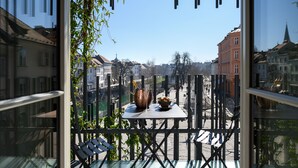 Uma varanda com mesa, cadeiras e vista para a cidade.