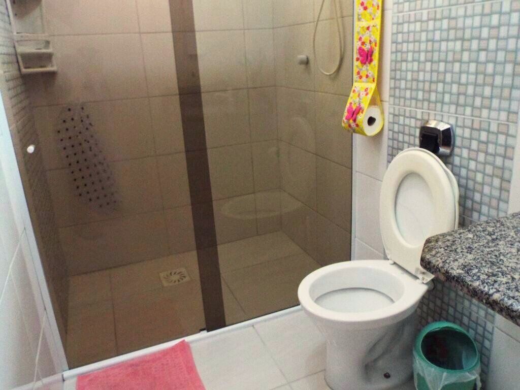 Een badkamer met een douche, toilet en wastafel.