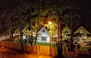 Stunning house with a prominent roofline and inviting front porch, set amidst a, tree-lined setting.