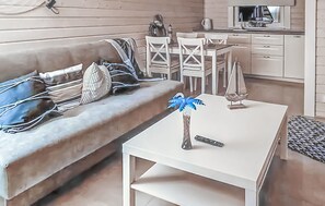 Relax in this stylish living room with a beige sofa, coffee table, and dining area.