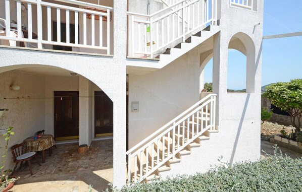 A two-story building with a balcony, a staircase, and a patio area with outdoor furniture. - Gorgeous apartment in Racisce with house sea view (Racisce)
