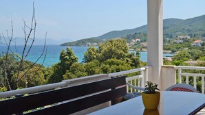 A balcony with a bench, a table, and a potted plant. - Gorgeous apartment in Racisce with house sea view (Racisce)