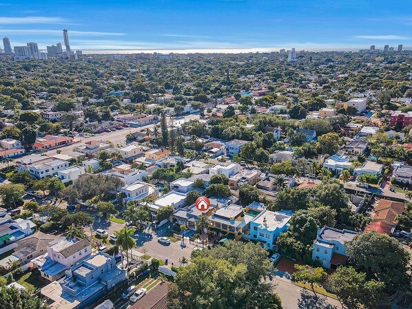 An aerial view of a densely populated urban area with a mix of residential and commercial buildings, roads, and greenery.