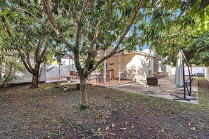 A patio area with a table and chairs, a covered seating area, and a building with a sign that reads 'Café'. - Private Studio steps From Calle 8 (Free Parking) (Miami)