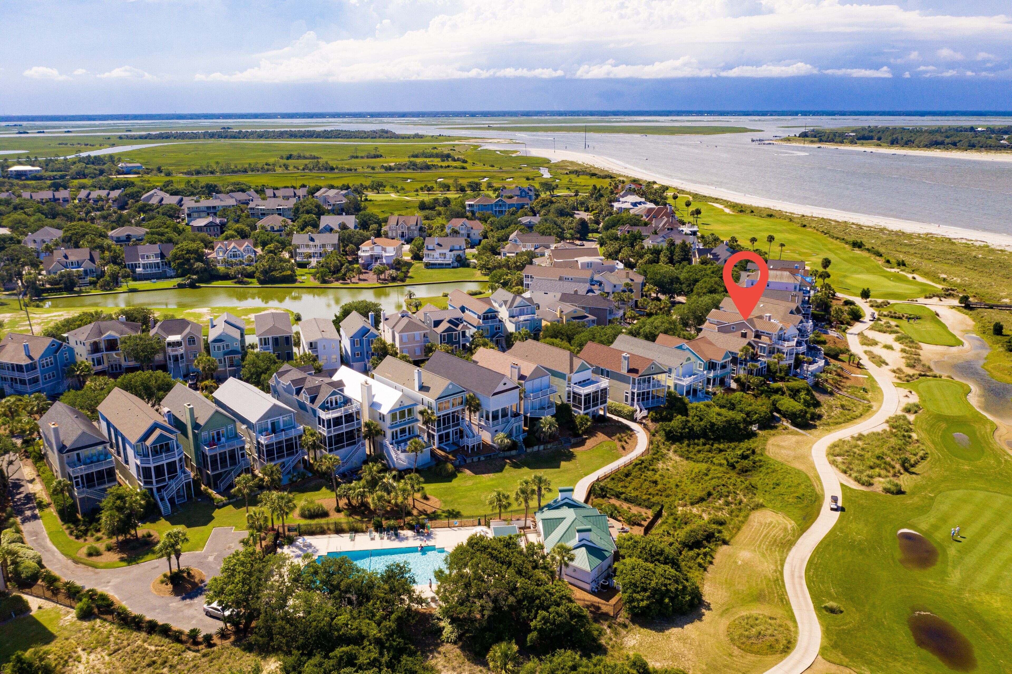 A residential area with houses, a golf course, and a beach.