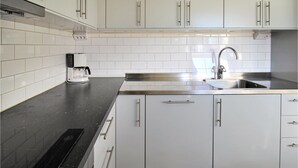 A modern kitchen with white cabinets, a stainless steel sink, and a coffee maker on the countertop. - Stunning home in Grimslöv with sauna (Grimslöv)
