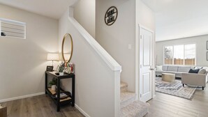 Un escalier menant à un salon équipé d’un canapé et d’un tapis.