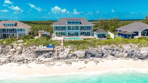 A beachfront property with a large house, a swimming pool, and a rocky shoreline. - Shades of Blue a luxury home on private beachfront sleeps 20ppl, chef, boat tour (Forbes Hill)