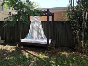 A wooden pergola with a canopy, a swing, and a lantern. - Studio in Little Havana w/ Parking (Miami)
