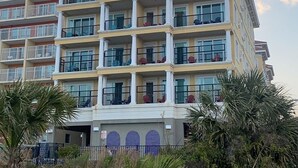 A multi-story hotel with balconies, a central atrium, and a view of the sky. - Jellyfish 2 BR Oceanfront Condo with Pool (Myrtle Beach)
