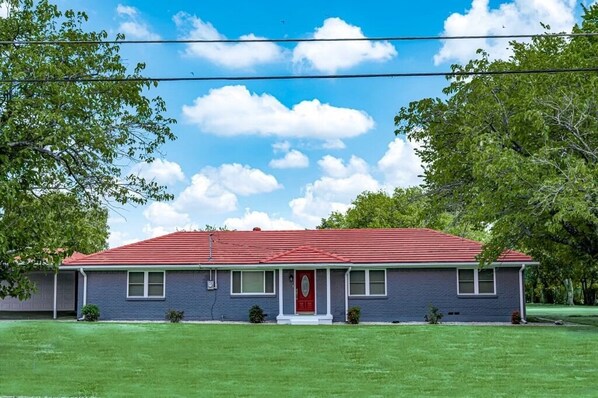 A single-story house with a red roof, a front porch, and a red door. - Perfect for Families & Groups (Cedar Hill)