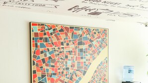 Un espace repas agrémenté d’une œuvre d’art en mosaïque, d’un distributeur d’eau et d’une petite table avec des chaises.