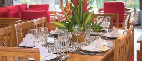 A dining table set with chairs, a centerpiece, and tableware.