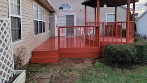 Ein Haus mit roter Veranda und überdachtem Bereich.