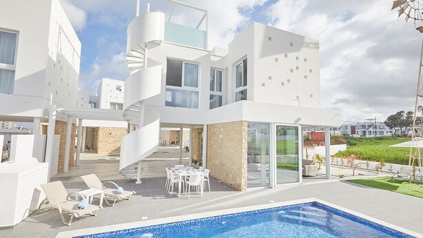 A modern hotel with a swimming pool, outdoor seating, and a spiral staircase. - Protaras Vie Bleu Villa VB15 -  a villa that sleeps 7 guests  in 3 bedrooms (Unknown)