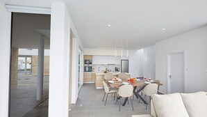 A modern kitchen with a dining area, a sofa, and a view of the outside. - Protaras Vie Bleu Villa VB15 -  a villa that sleeps 7 guests  in 3 bedrooms (Unknown)