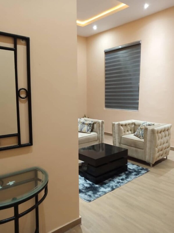 A living room with two sofas, a coffee table, and a glass table.