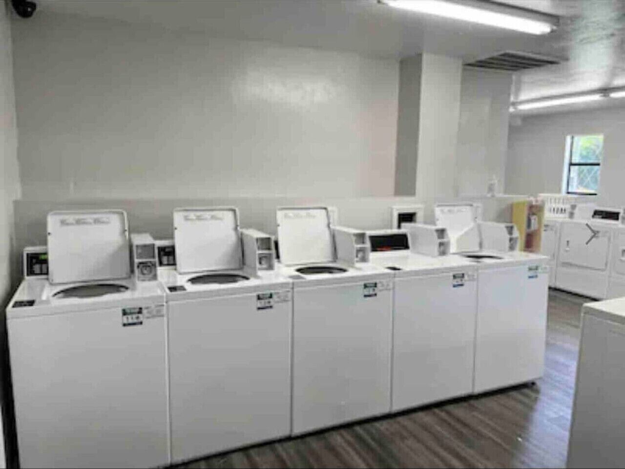 A laundry facility with multiple washing machines and dryers.