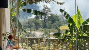 Una stanza con un'ampia finestra che si affaccia su un rigoglioso giardino.