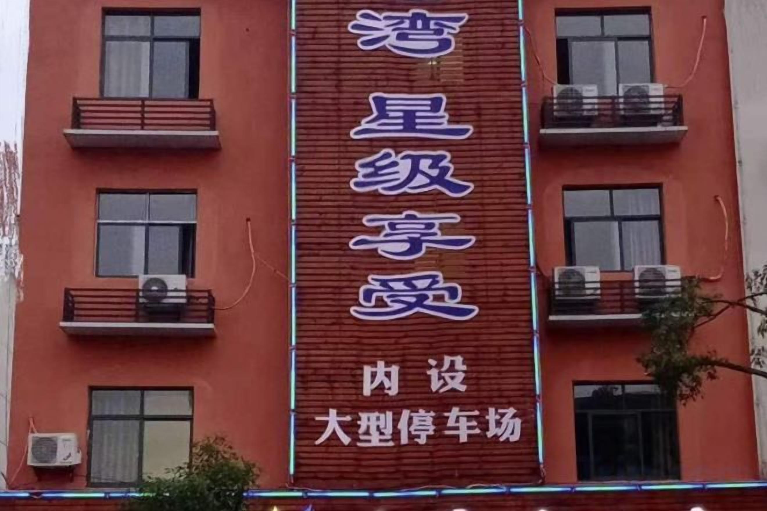 A building with a vertical sign that reads '星级享受' and '内设大型停车场'.