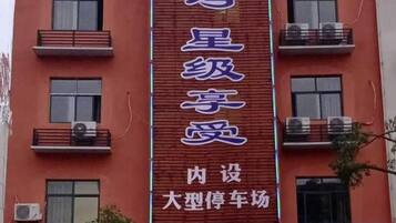 A building with a vertical sign that reads 'ๆ็บงไบซๅ' and 'ๅ
่ฎพๅคงๅๅ่ฝฆๅบ'.