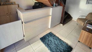 A modern interior with a staircase, a built-in desk, and a seating area. - Hotel Real Koerich 24h (Rio do Sul)