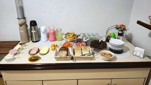 A buffet table with various food items, condiments, and utensils. - Hotel Real Koerich 24h (Rio do Sul)