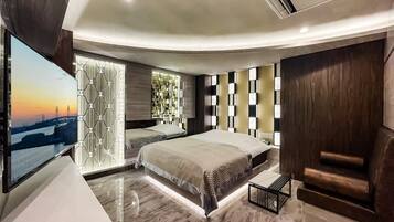 A modern bedroom with a large bed, a TV, and a cityscape view.