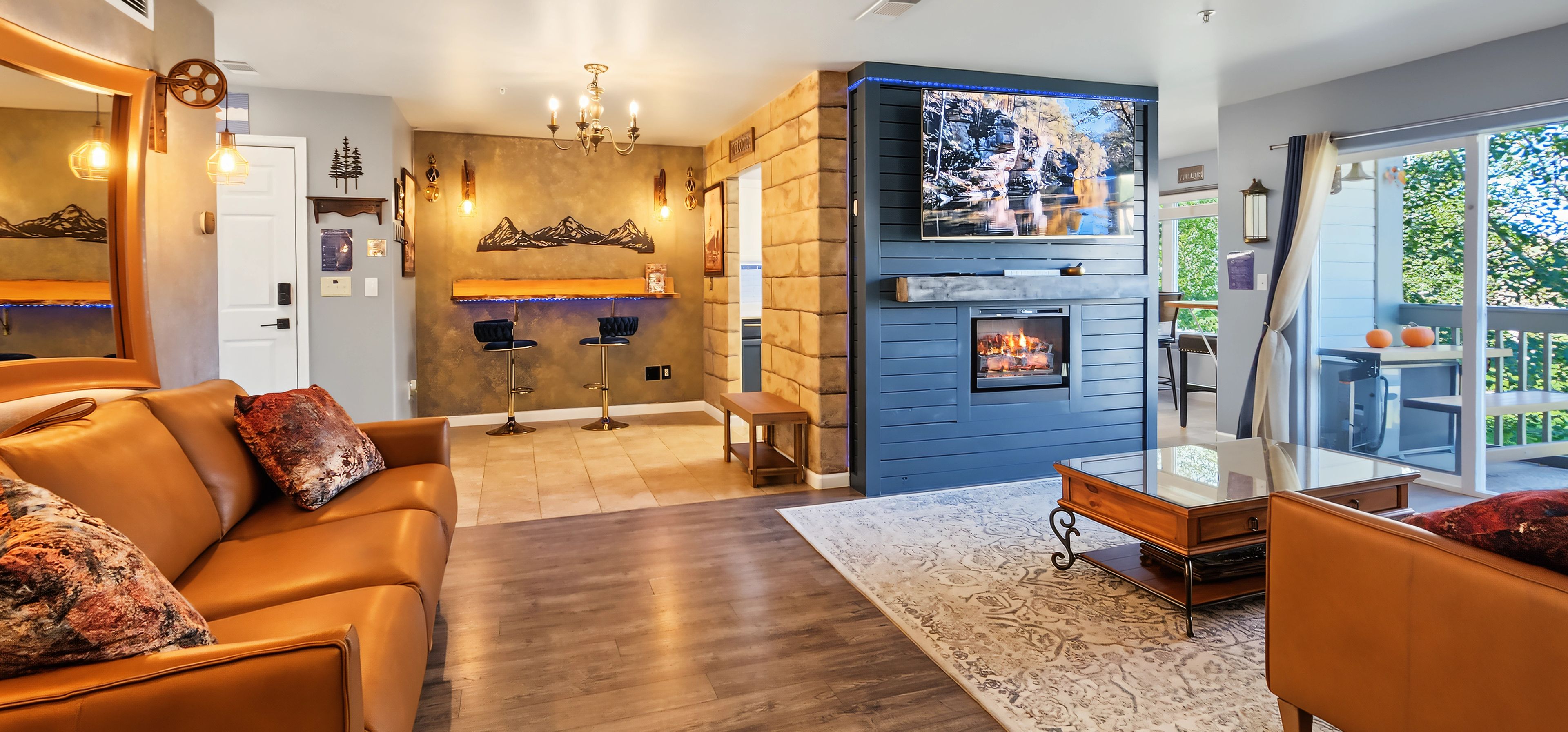Una sala de estar moderna con chimenea, sofás de cuero y un comedor.
