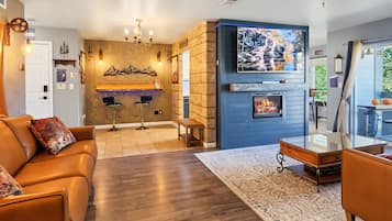 Una sala de estar moderna con chimenea, sofás de cuero y un comedor.