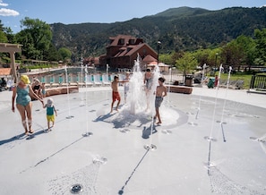 A water play area with multiple fountains, a pool, and a building in the background. - Mountain View Hideaway, 14 Min to Glenwood Hot Springs, 2 King Beds, Golf Views (New castle)