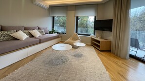 A modern living room with a sofa, coffee table, and TV. - Acropolis Residence with 360-Degree Athens City Views Rooftop (Athina)