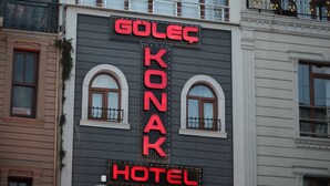 A hotel with a neon sign reading "Golec Konar Hotel" and a sign for "Sultan Supermarket" below. - Gulec Konak Hotel (Istanbul)