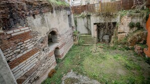 A courtyard with brick walls, a staircase, and a small garden area. - Gulec Konak Hotel (Istanbul)