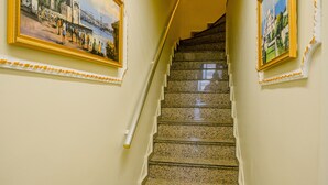 A staircase with a handrail, flanked by two framed paintings on the walls. - Gulec Konak Hotel (Istanbul)