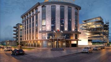 A modern hotel with a curved facade, multiple floors, and a prominent entrance.