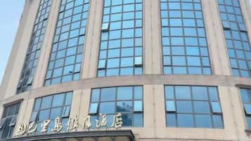 A tall building with a series of windows and a sign with Chinese characters.