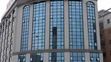 A multi-story hotel with a curved facade, large windows, and a sign indicating it is a hotel.