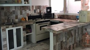 A kitchen with a tiled backsplash, a built-in oven, a sink, and a window. - Apartment in Diamante area Acapulco (Acapulco)
