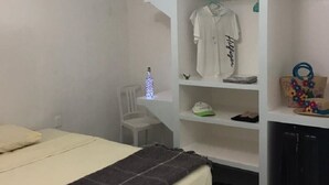 A bedroom with a bed, a ceiling fan, a wardrobe, and a desk with a chair. - Apartment in Diamante area Acapulco (Acapulco)