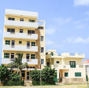 A multi-story residential building with balconies, a palm tree, and a clear sky. - Room-hotel Ah Maio - Double or Twin 1 (Maio)