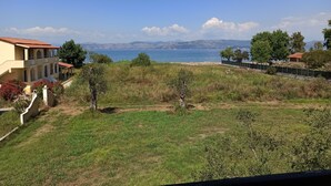 A coastal property with a view of the sea, a grassy area, and a building with a red roof. - Summer Desire - One Bedroom Apartment With Sea View (Corfu)