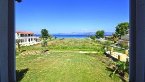 A view of a grassy area with a clear blue sky and a distant view of the sea. - Summer Desire - One Bedroom Apartment With Sea View (Corfu)