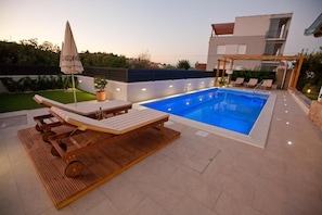 A modern outdoor pool area with lounge chairs and a pergola. - Spacious Apartment Milly With Pool (Preko)