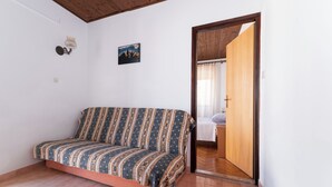 A room with a sofa, a wooden door, and a tiled floor. - Close To The Sea, 1-bedroom Apartment Sonia (Kukljica)