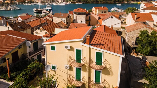 A coastal town with terracotta-roofed buildings, a marina with boats, and lush greenery. - Close To The Sea, 1-bedroom Apartment Sonia (Kukljica)