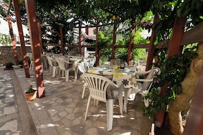 Relax in style with comfortable seating and dining areas under a shaded pergola.
